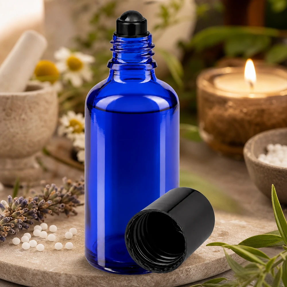 Apothekenflasche blau 50ml Roll-On Verschluss schwarz Geöffnete blaue 50ml Glasflasche mit Roll-On Aufsatz zwischen Lavendel Kamille und Kräutern