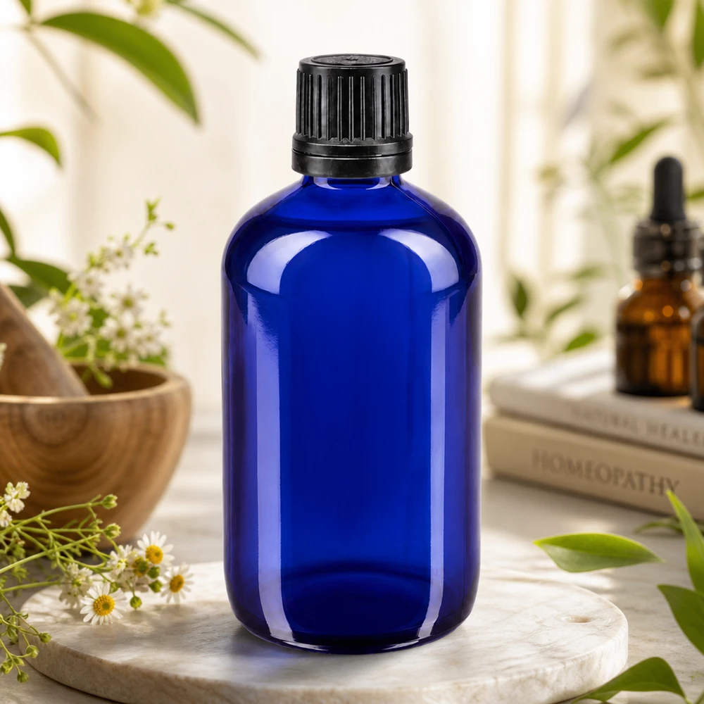 Apothekenflasche blau 100ml Schraubverschluss schwarz Giessring Originalitätsverschluss Kobaltblaue Glasflasche 100ml mit OV-Schraubverschluss schwarz vor Homöopathie-Büchern