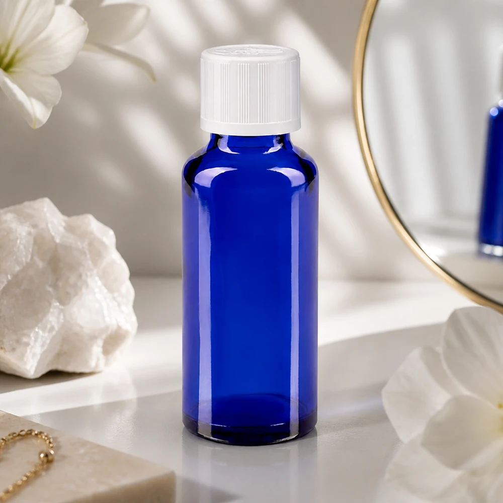 Apothekenflasche blau 30ml Schraubverschluss weiß Kindersicherung Standard Blaue Glasflasche 30ml mit kindersicherem Schraubdeckel neben Kristallstein und Goldschmuck