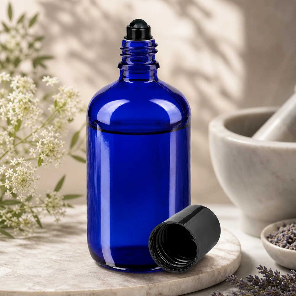 100ml blaue Apothekerflasche mit Roll-On Verschluss auf Marmortablett mit Heilkräutern