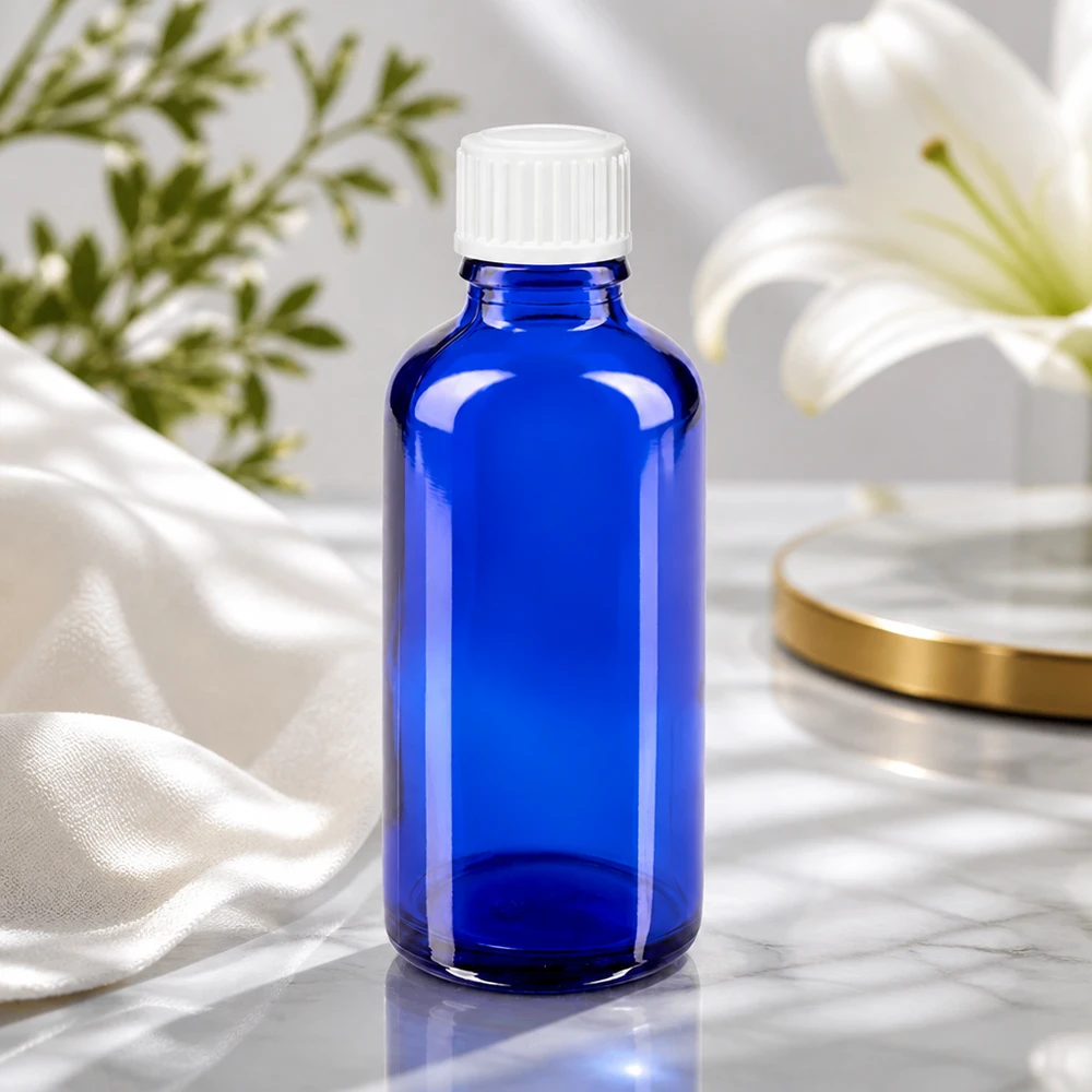 Kobaltblaue Apothekerflasche 50ml mit kindersicherem Weißverschluss vor elegantem Blumenarrangement