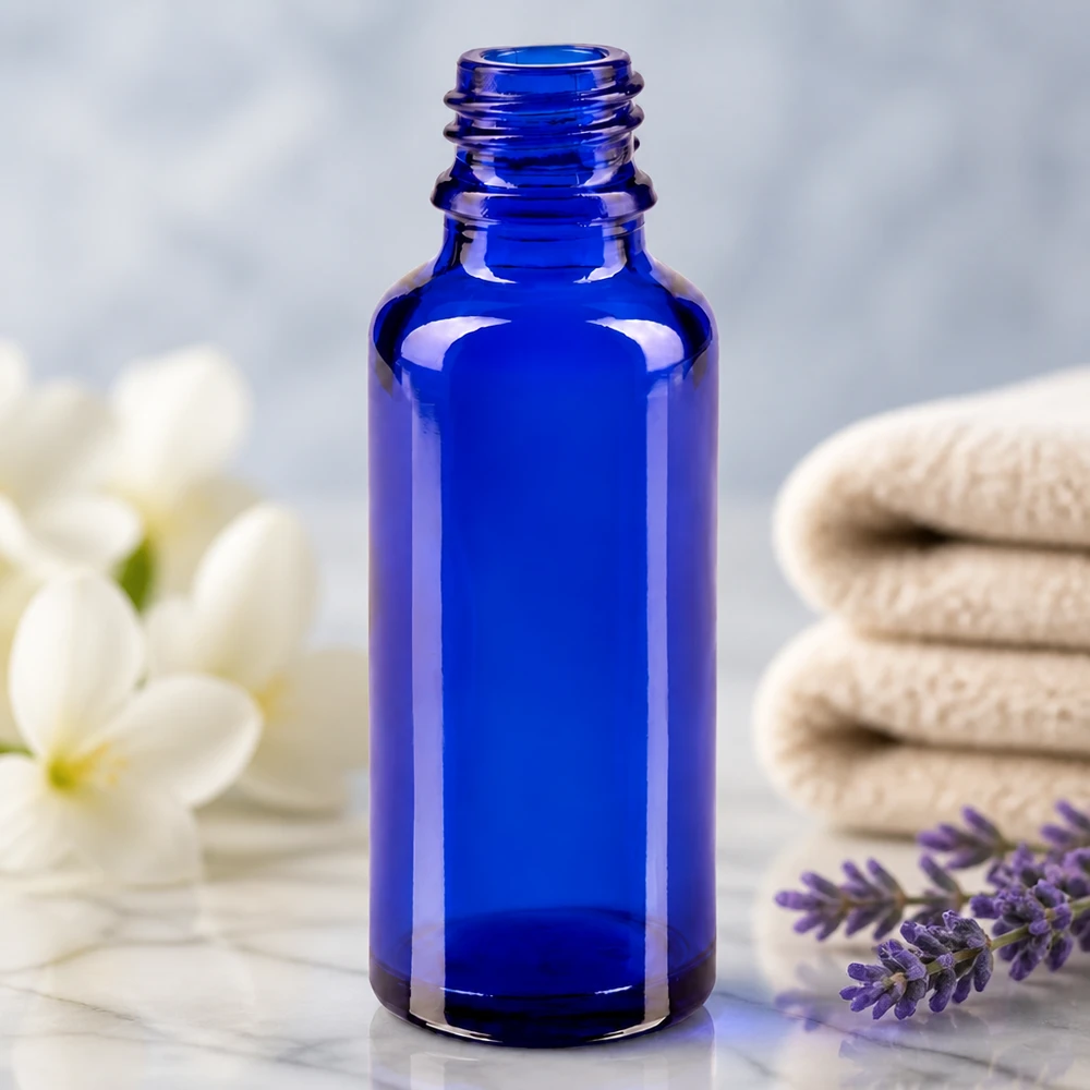 Tropfflasche 30ml DIN 18 BLAUGLAS Kobaltblaue ApoGlas Flasche 30ml auf Marmor mit gefalteten Handtüchern im Wellness-Setting