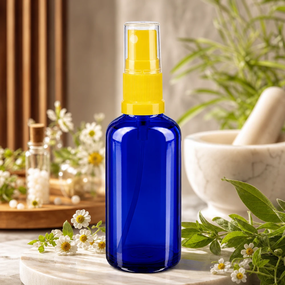Apothekenflasche blau 50ml Sprayaufsatz gelb 50ml Zerstäuberflasche aus blauem Apoglas mit gelbem Pumpkopf neben Mörser und Kräutern