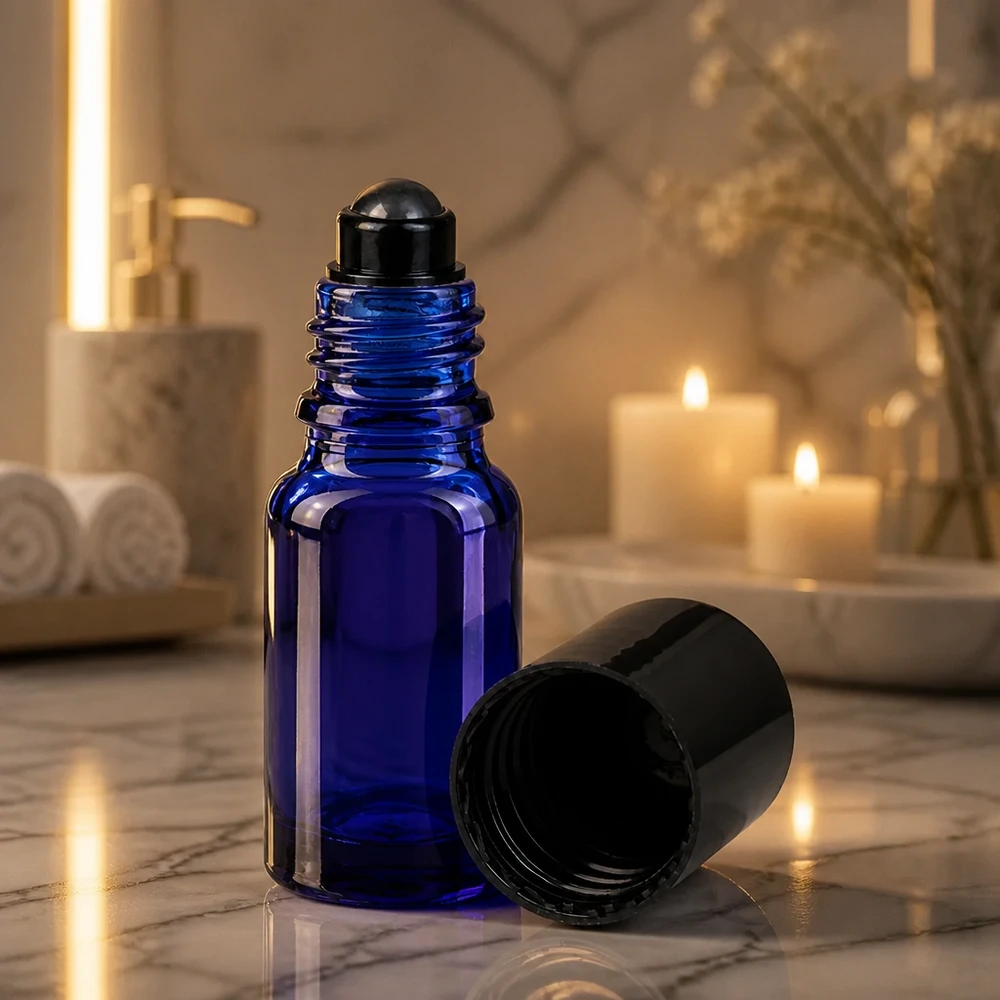 Kleine blaue Apothekerglas Flasche 10ml mit Roll-On Aufsatz neben brennenden Kerzen