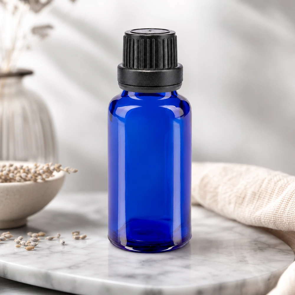 Kleine blaue Glasflasche 20ml mit geripptem Schraubverschluss auf Marmor Untergrund