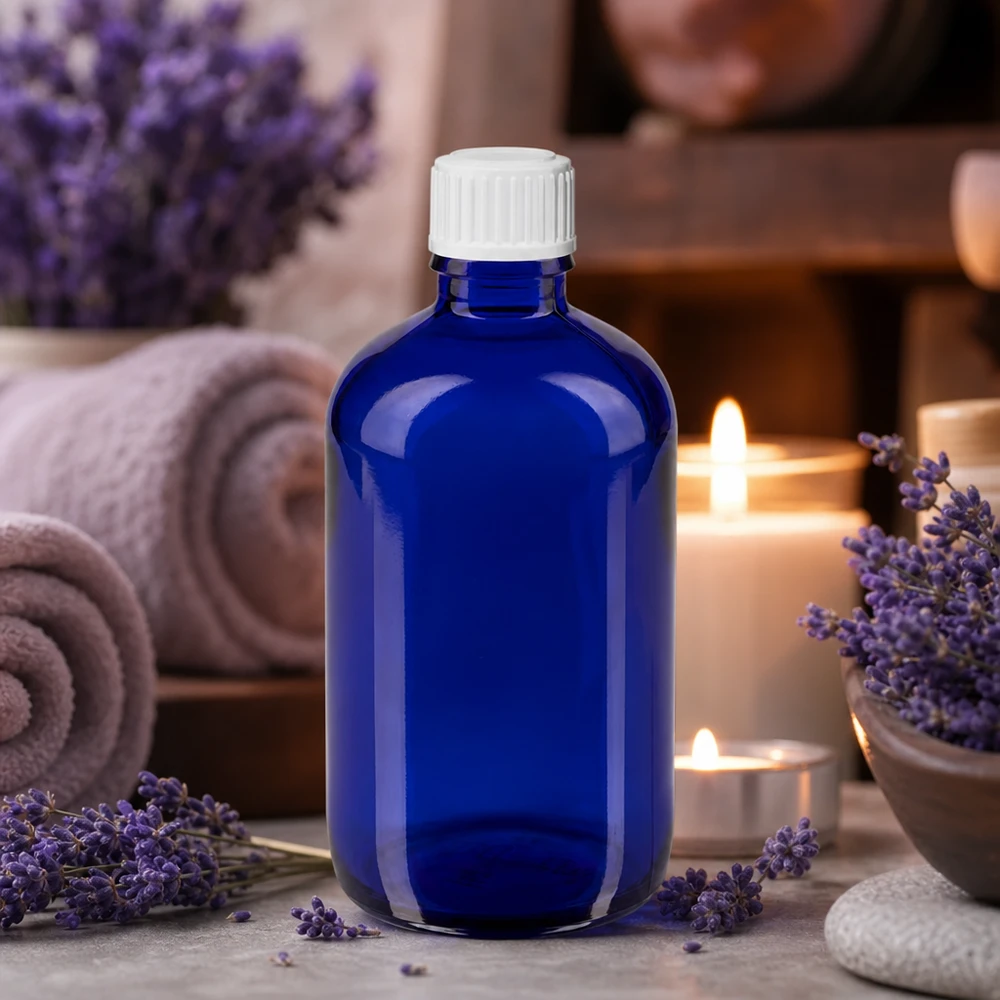 Apothekenflasche blau 100ml Tropfverschluss weiß 0.8mm Standard Blaue 100ml Glasflasche mit weißem Tropfeinsatz zwischen Lavendelblüten und Entspannungskerzen