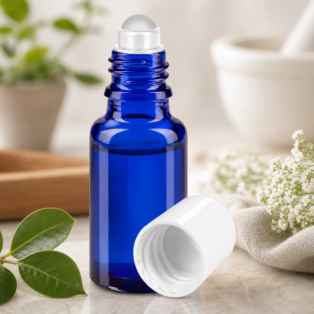 Kobaltblaue Roll-On Flasche 20ml mit geöffnetem weißen Schraubdeckel auf hellem Marmoruntergrund