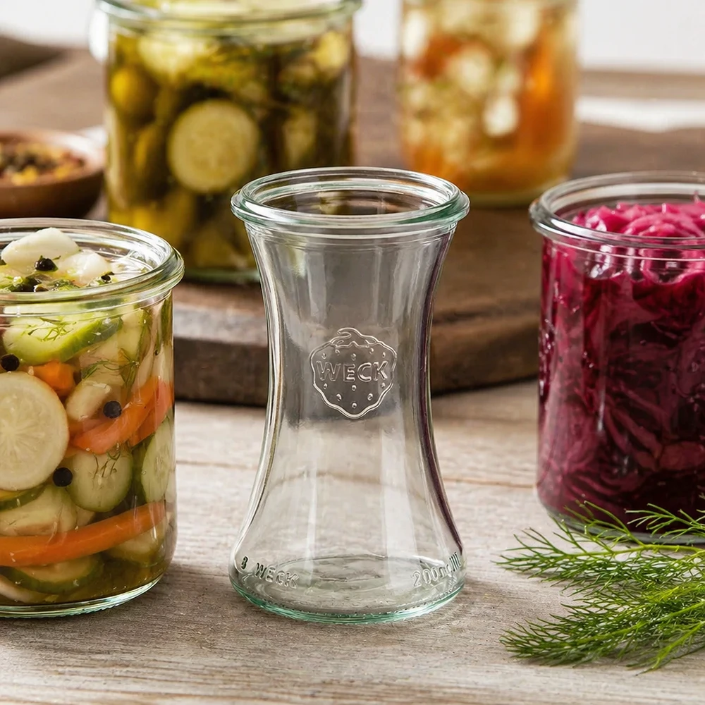 WECK RR60 Delikatessenglas 200ml zwischen bunten eingelegten Gemüsegläsern und Einmachgläsern auf Holzuntergrund