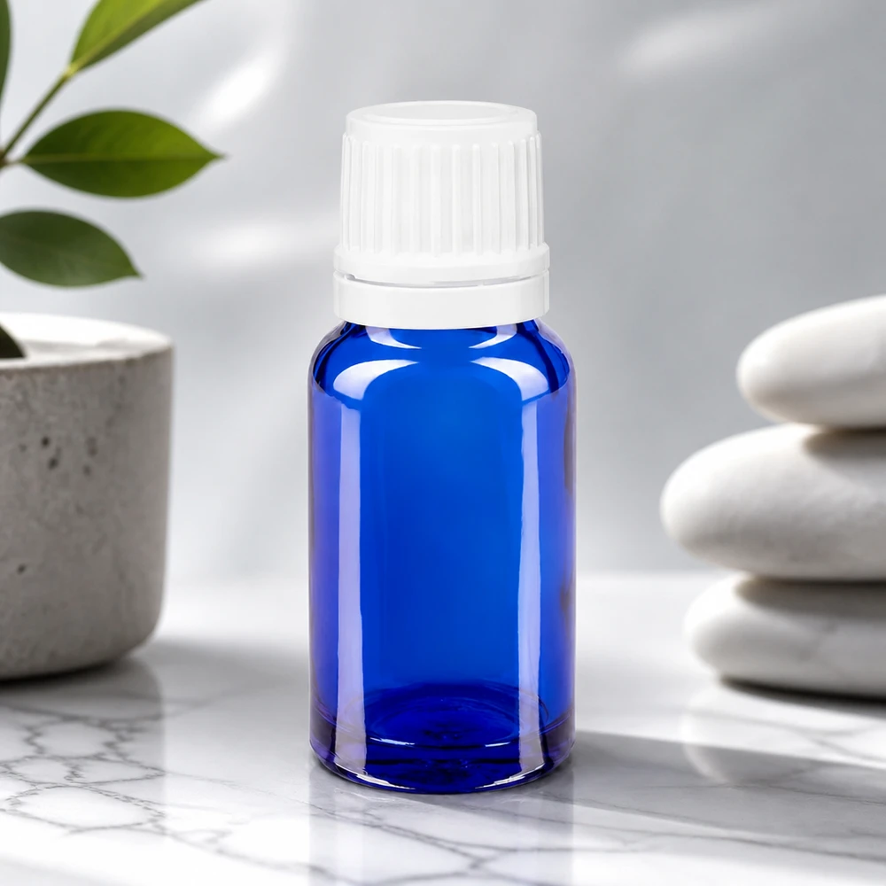 Kobaltblaues Fläschchen 10ml mit 0,7mm Präzisionstropfeinsatz neben Zen-Steinen