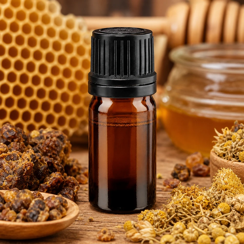 5ml Braunglasflasche mit OV-Verschluss umgeben von Propolis Bienenwachs und Kamillenblüten
