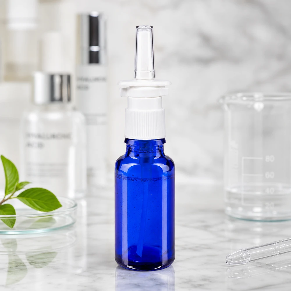Kobaltblaue 20ml Glasflasche mit Nasenspray-Pumpe und transparenter Applikationsdüse im Labor-Setting