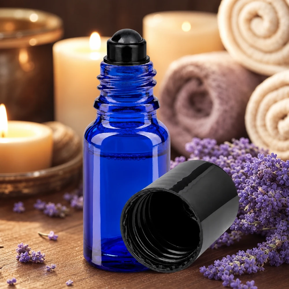 Kobaltblaue Roll-On Glasflasche 10ml neben lila Lavendelblüten und brennenden Kerzen