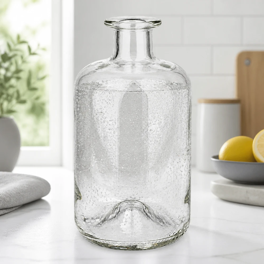 Apothekerflasche Luna 500ml mit Bubble-Textur auf weißer Küchenarbeitsplatte neben Zitronen und Pflanzen