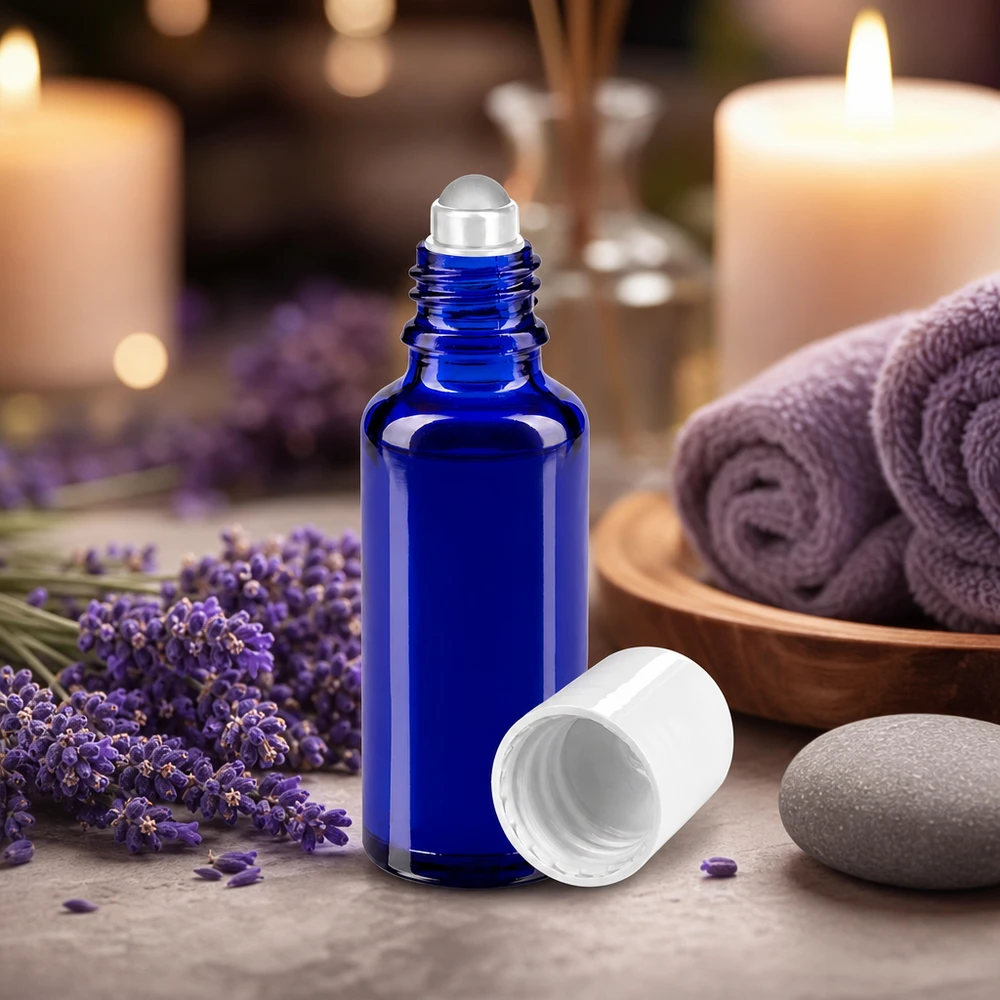 Apothekenflasche blau 30ml Roll-On Verschluss weiß Blaue Aromatherapie Rollflasche 30ml mit Glasroller vor Lavendelblüten und Kerzen