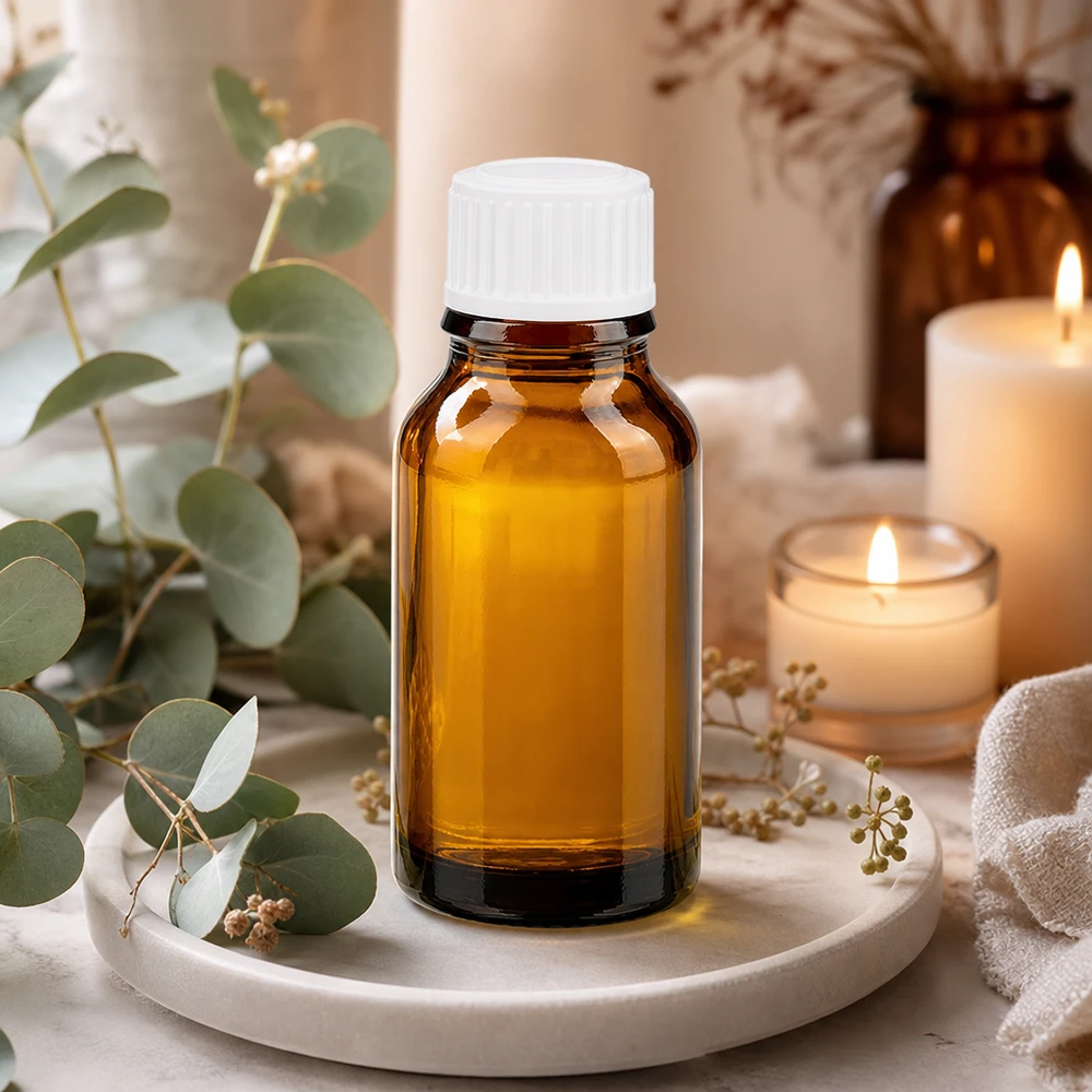 Apothekerflasche aus Braunglas 15ml weißer Verschluss neben Kerzen und Naturdekor