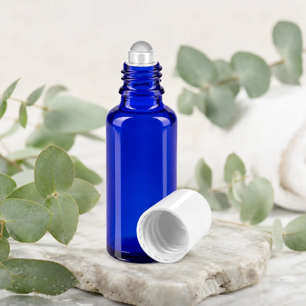 Blaue Glasflasche 30ml mit Rollkugel-Applikator für ätherische Öle auf Natursteinuntergrund