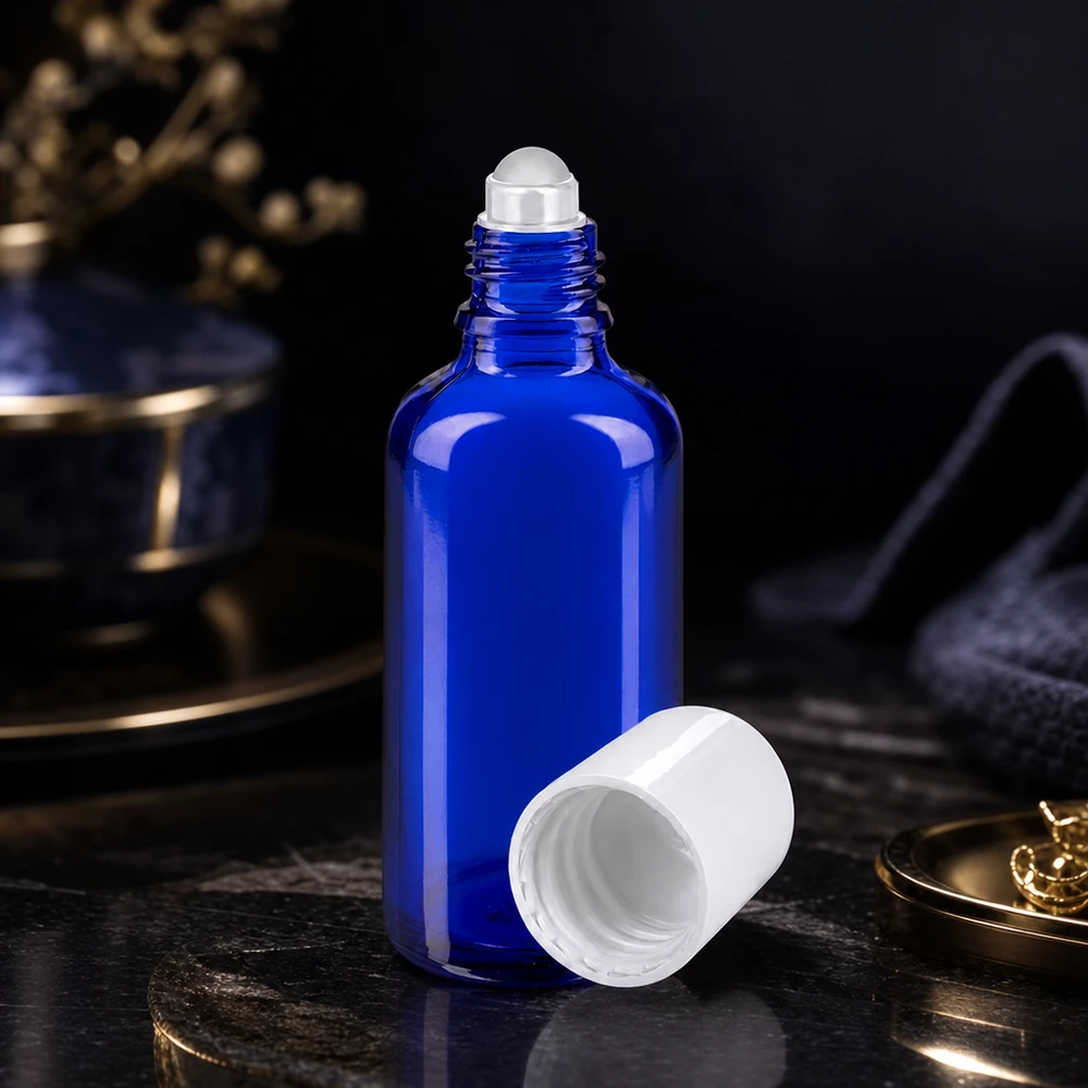 Blaue Roll-On Flasche 50ml STD mit abgenommenem weißen Deckel neben Goldaccessoires im Luxusambiente
