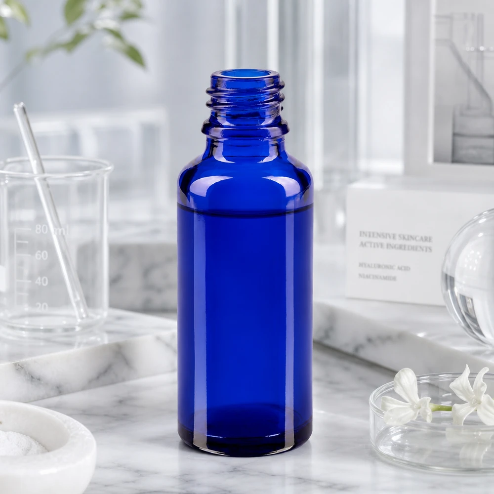 Leere blaue Apothekenflasche ApoGlas 30ml mit offenem Schraubgewinde auf weißem Marmor