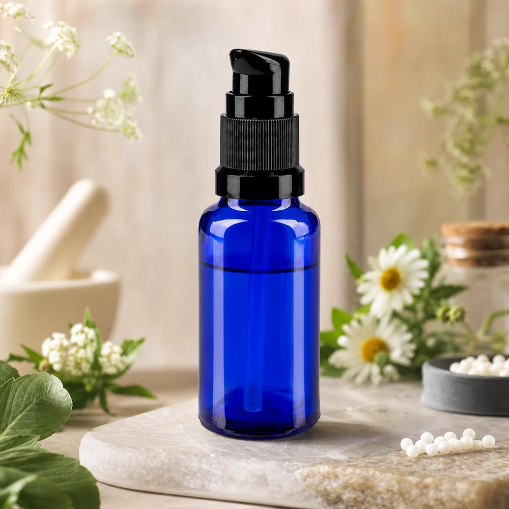 Blaue 20ml Dosierflasche ApoGlas STD mit schwarzer Pumpe zwischen Kamillenblüten