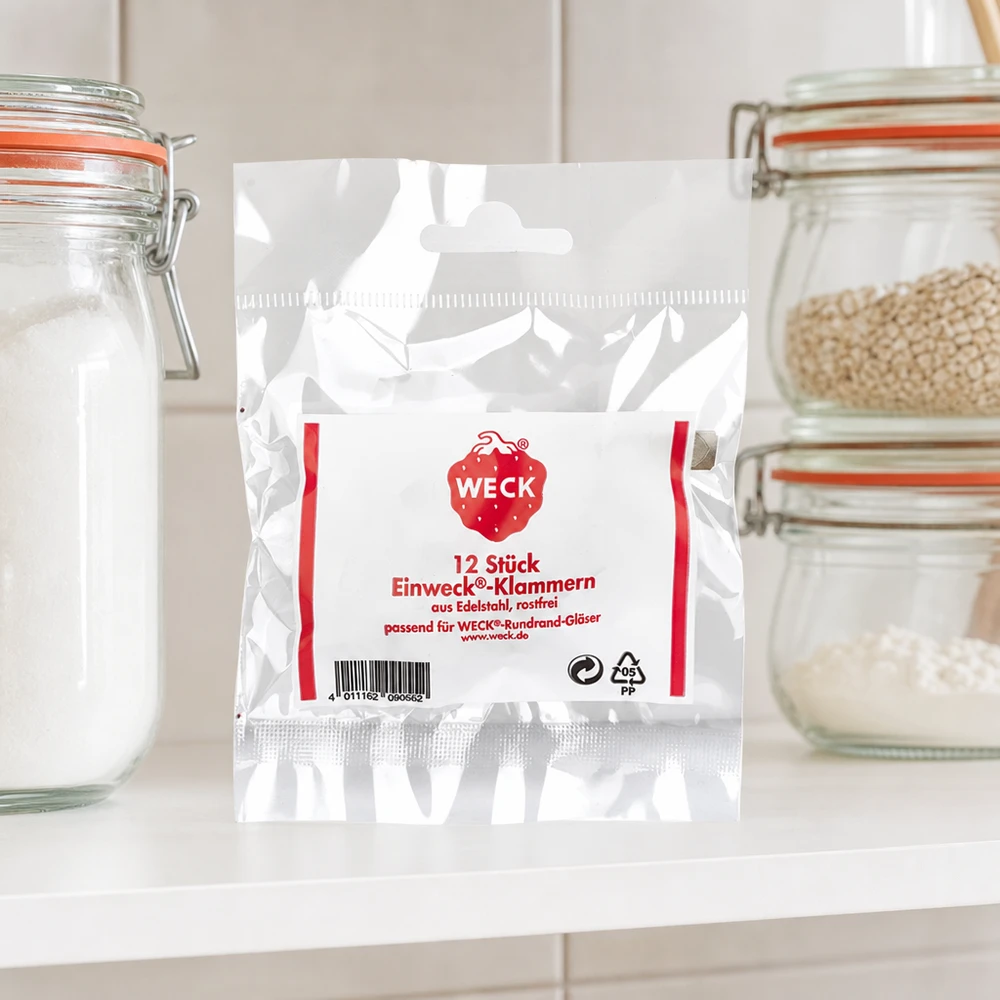 Klammern Original WECK (Pack(s) mit 12 Stück) WECK Klammern Produktverpackung in Küche zwischen Vorratsgläsern mit Getreide Mehl auf weißer Arbeitsplatte Küchenambien