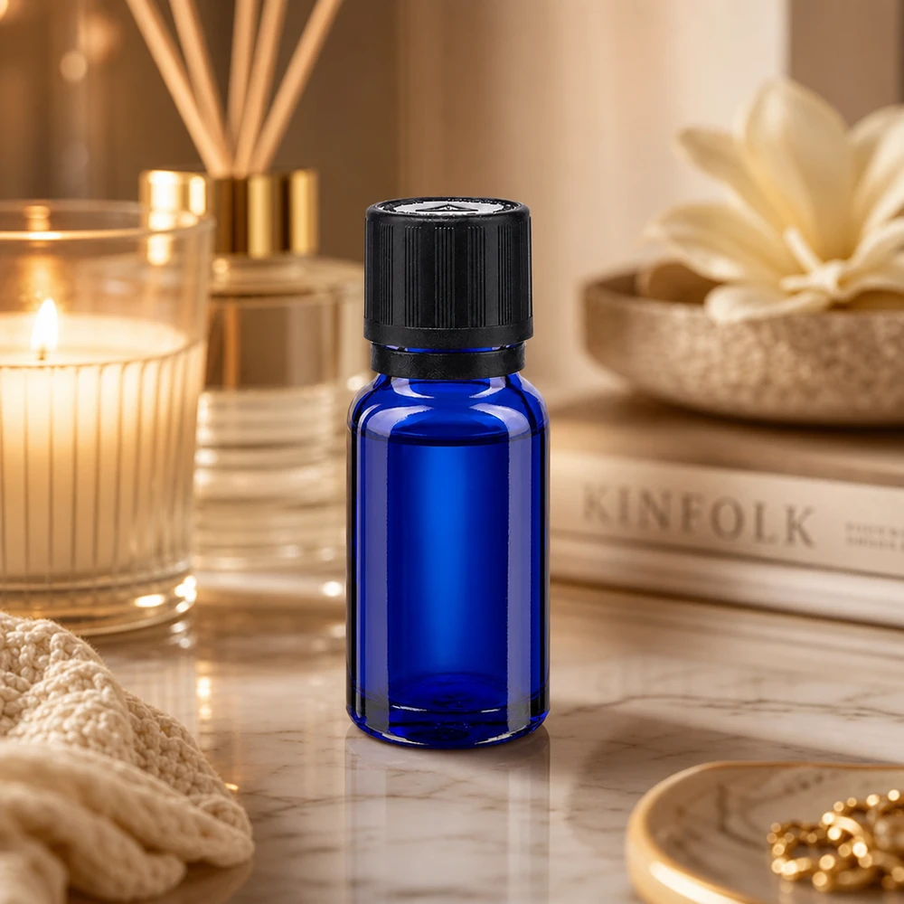 10ml Tropfflasche aus kobaltblauem Apothekerglas neben Raumduft-Diffuser und Kerze