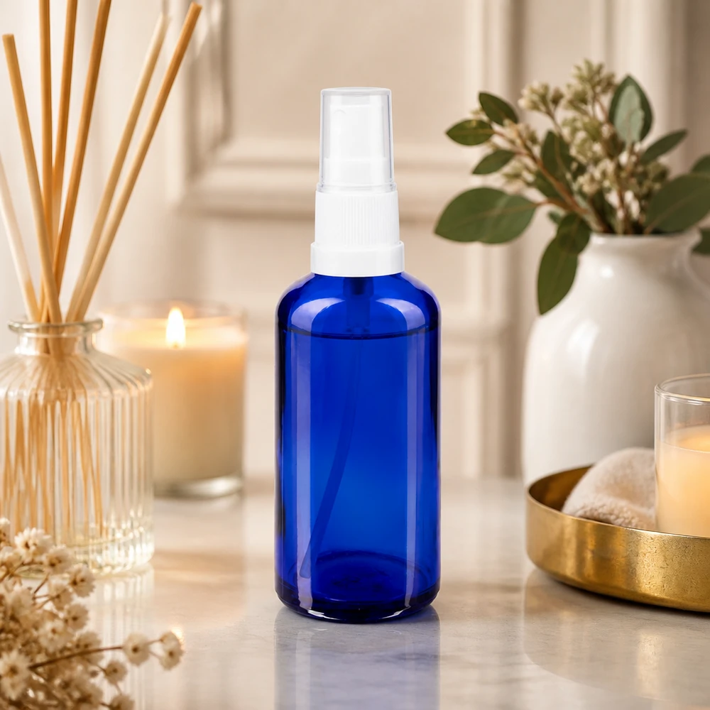 Apothekenflasche blau 50ml Sprayaufsatz weiß Kobaltblaue 50ml Glasflasche mit weißem Zerstäuber neben Duftdiffuser und Kerzen