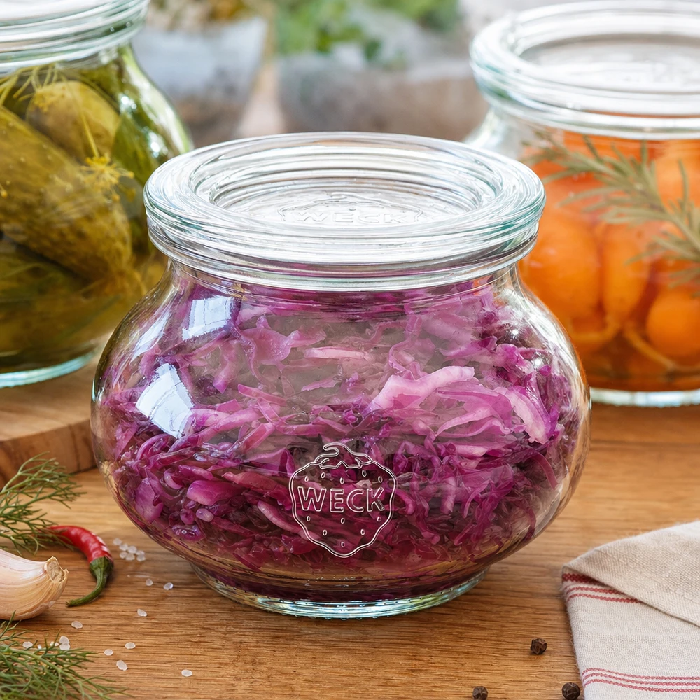 WECK Schmuckglas 220ml mit violettem Rotkohl gefüllt zwischen anderen Einmachgläsern Küchenszenerie Fermentation