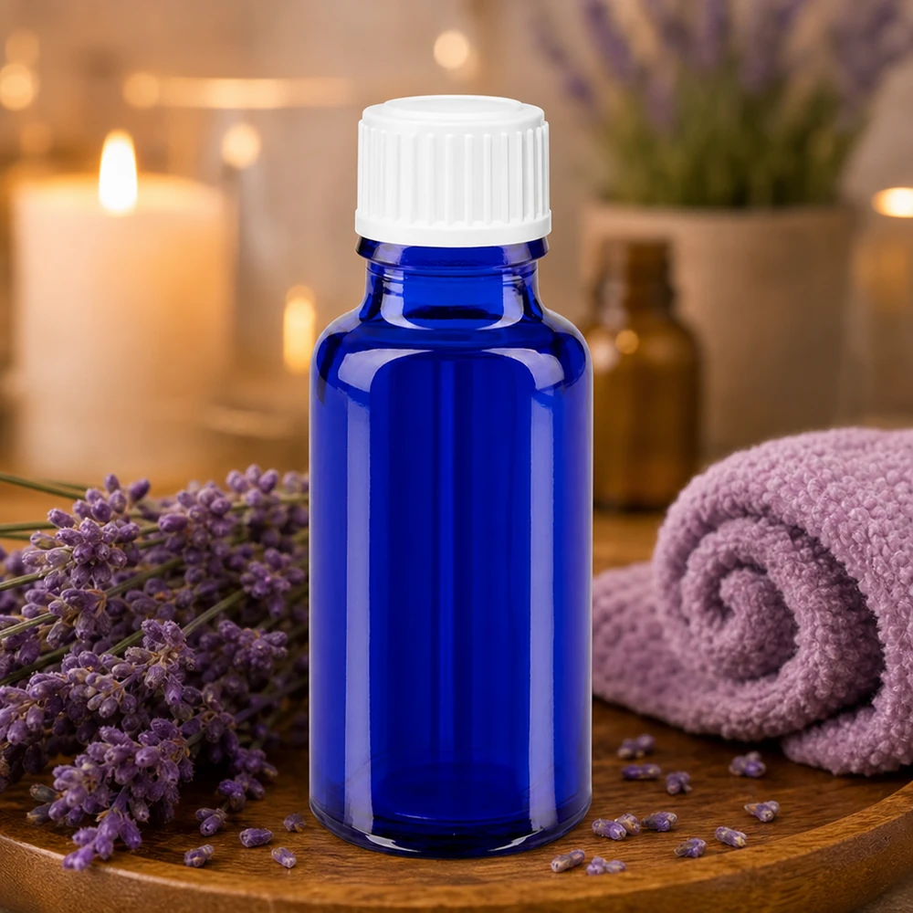 Kleine blaue Apothekerflasche 20ml neben gerolltem Lavendeltuch und Kerzen