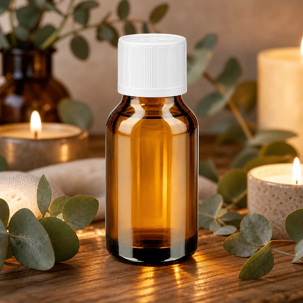 Kleine 30ml Braunglasflasche mit weißem Sicherheitsverschluss umgeben von Eukalyptuszweigen und Kerzen
