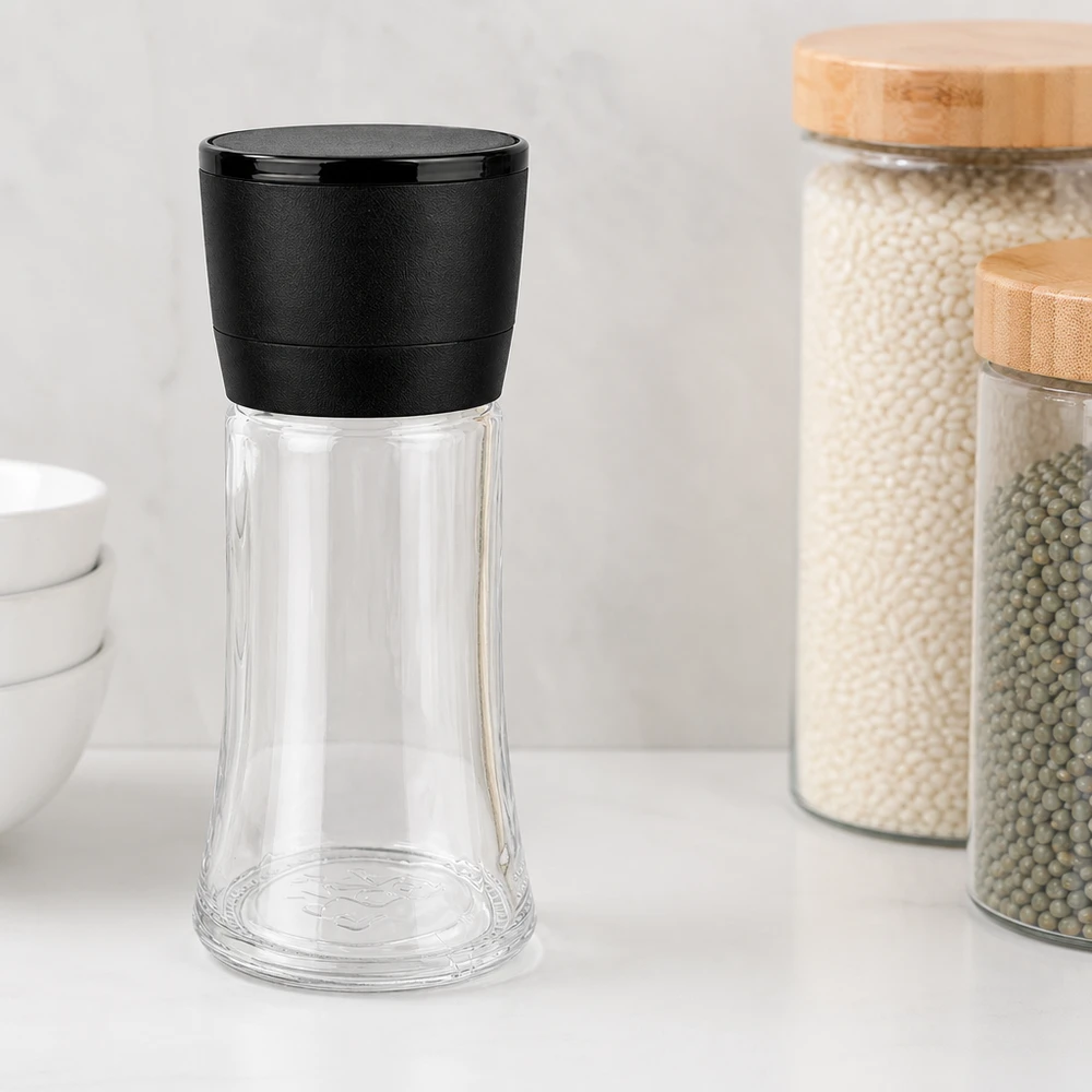Salz-/Gewürzglas 95ml mit Mühle Vario schwarz Transparentes Gewürzglas 95ml mit schwarzer Vario-Mühle neben Vorratsgläsern mit Holzdeckel