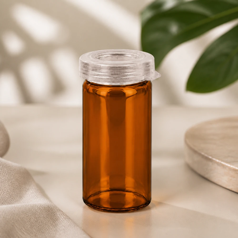 Kleines Apothekerglas 5ml in Braunglas mit kindersicherem Schnappdeckel neben Monstera-Blatt